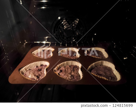 Freshly baked heart shaped blueberry muffins nestled in dark oven, radiating warm, sweet fragrance for Mother's Day Valentines 124815699