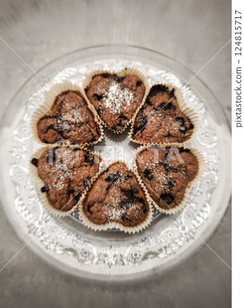 Chocolate blueberry heart shaped muffins sprinkled with powdered sugar resting on elegant glass plate, presenting decadent dessert for Mother's Day Valentines copy space Chocolate blueberry heart shaped muffins sprinkled with powdered sugar resting on elegant glass plate, presenting decadent dessert for Mother's Day Valentines copy space 124815717