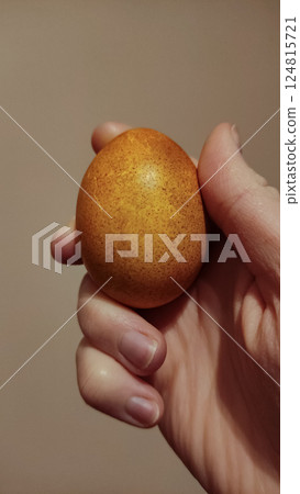 Golden onion skin dyed easter egg nestled in gentle hand, embodying seasonal festive tradition copy space Golden onion skin dyed easter egg nestled in gentle hand, embodying seasonal festive tradition copy space 124815721