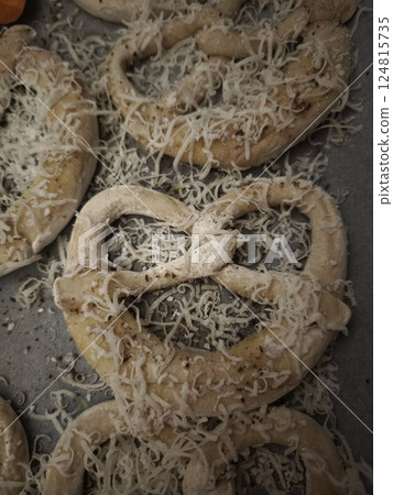 Freshly baked pretzels sprinkled with grated cheese and spices, resting on a baking sheet in a prague kitchen easy dinner 124815735