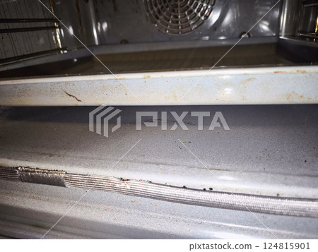 Dirty baking tray inside a home oven needs cleaning 124815901
