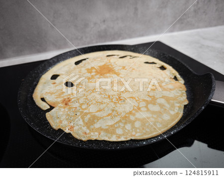 Cooking crepe on frying pan for shrove tuesday, maslenitsa or breakfast celebration Cooking crepe on frying pan for shrove tuesday, maslenitsa or breakfast celebration 124815911