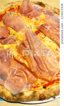 Crispy pizza topped with tomato sauce, melted mozzarella, prosciutto cotto, served outdoors in summer bibione, italy Crispy pizza topped with tomato sauce, melted mozzarella, prosciutto cotto, served outdoors in summer bibione, italy 124815936