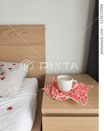 Warm coffee resting on heart printed napkin near rumpled bedsheets, suggesting intimate valentine's morning surprise Warm coffee resting on heart printed napkin near rumpled bedsheets, suggesting intimate valentine's morning surprise 124815999