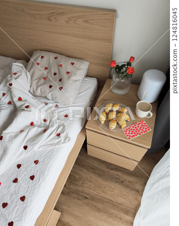 Romantic bedroom morning with heart bedding, fresh croissants, roses, coffee for valentine's breakfast surprise 124816045