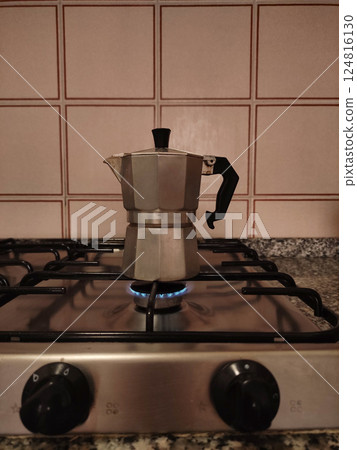 Traditional italian moka pot brewing rich coffee on vintage gas stove, highlighting authentic espresso making process in rustic kitchen setting Traditional italian moka pot brewing rich coffee on vintage gas stove, highlighting authentic espresso making process in rustic kitchen setting 124816130