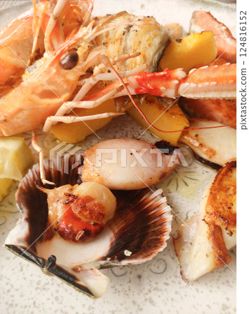 Close up of a delectable seafood platter featuring grilled prawns, scallops, and lemon wedges, showcasing italian culinary artistry in bibione, italy Close up of a delectable seafood platter featuring grilled prawns, scallops, and lemon wedges, showcasing italian culinary artistry in bibione, italy 124816152