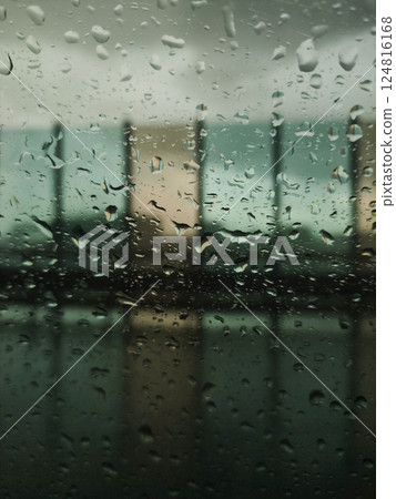 Raindrops blurring city skyline through glass window, moody urban landscape during rainy summer day in Prague Raindrops blurring city skyline through glass window, moody urban landscape during rainy summer day in Prague 124816168