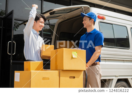Asian delivery man delivers parcel to a customer at home office, fast shipping, e-commerce, and professional courier service. Asian delivery man delivers parcel to a customer at home office, fast shipping, e-commerce, and professional courier service. 124816222