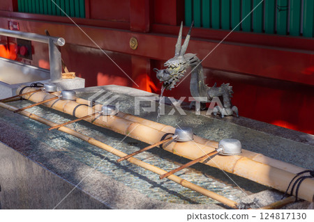 [日本] 在東京千代田區神田神社的噴水池裡，竹竿上擺放著龍雕塑和水勺 124817130
