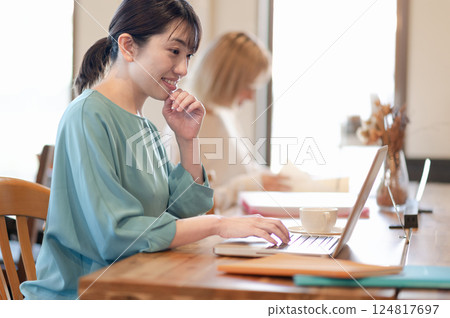 一位在咖啡館遠距辦公的女士和一位正在學習的年輕女士 124817697