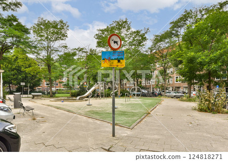 A vibrant playground stands amidst lush greenery, featuring a slide and playful activities, perfect for children's recreation and outdoor fun. A vibrant playground stands amidst lush greenery, featuring a slide and playful activities, perfect for children's recreation and outdoor fun. 124818271