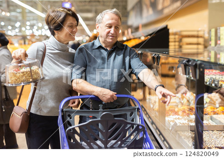 Married couple choose groceries together in supermarket Married couple choose groceries together in supermarket 124820049