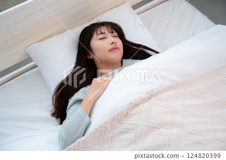 A young woman sleeping in bed A young woman sleeping in bed 124820399