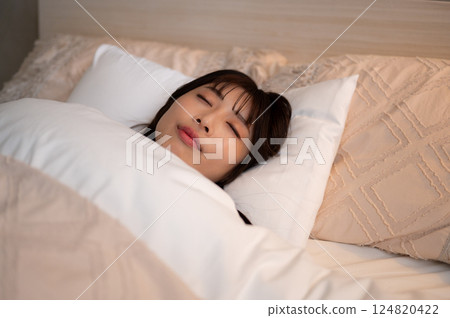 A young woman sleeping in bed A young woman sleeping in bed 124820422
