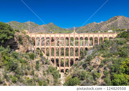Aguila aqueduct, bridge near The Nerja seaside town of The Costa del Sol coastline in Andalusia. Ancient aqueduct spanning a valley, impressive architecture against a backdrop of mountains. Aguila aqueduct, bridge near The Nerja seaside town of The Costa del Sol coastline in Andalusia. Ancient aqueduct spanning a valley, impressive architecture against a backdrop of mountains. 124820508