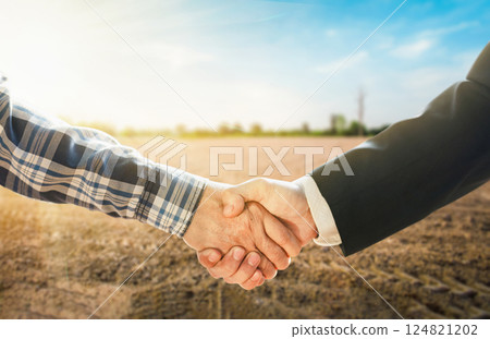 Business concept. Business handshake land purchase. Empty dry cracked swamp reclamation soil in real estate sale or property investment concept. Agriculture land plot for sales. 124821202