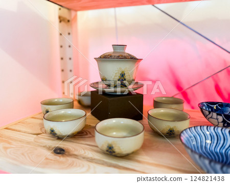 Traditional gaiwan with matching tea cups arranged on wooden surface. Harmony, ritual and elegance in Chinese tea ceremony Traditional gaiwan with matching tea cups arranged on wooden surface. Harmony, ritual and elegance in Chinese tea ceremony 124821438