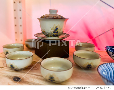 Traditional gaiwan with matching tea cups arranged on wooden surface. Harmony, ritual and elegance in Chinese tea ceremony Traditional gaiwan with matching tea cups arranged on wooden surface. Harmony, ritual and elegance in Chinese tea ceremony 124821439