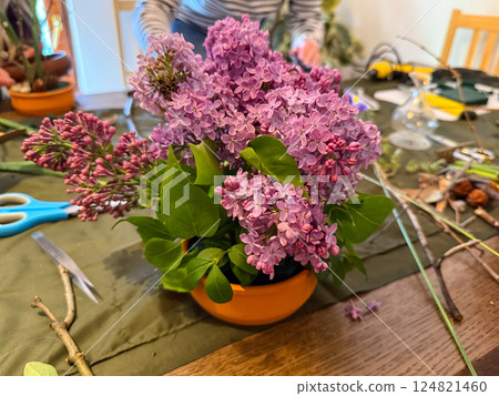 Lilac arrangement in progress on creative workspace. Natural beauty, floral art and mindfulness through ikebana composition 124821460