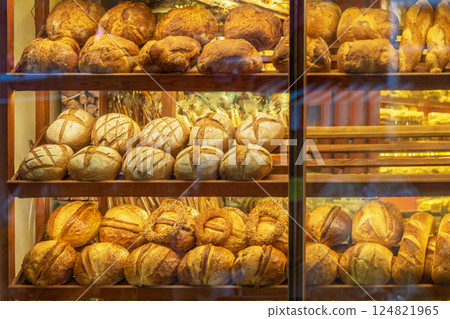 Fresh artisan bread in bakery display with golden crust and warm light. Bread display reflects comfort, tradition, daily food delight 124821965