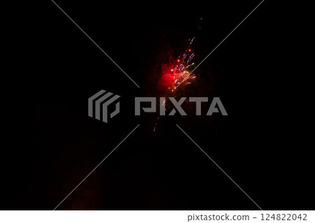 Colorful fireworks illuminate the night sky in a brilliant display above the city skyline during a festive celebration while gathering crowds cheer in amazement and delight 124822042