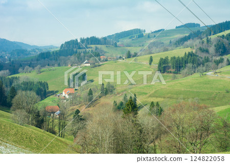 Serene landscape of rolling hills and charming cottages under a crisp blue sky in rural countryside during early spring Serene landscape of rolling hills and charming cottages under a crisp blue sky in rural countryside during early spring 124822058