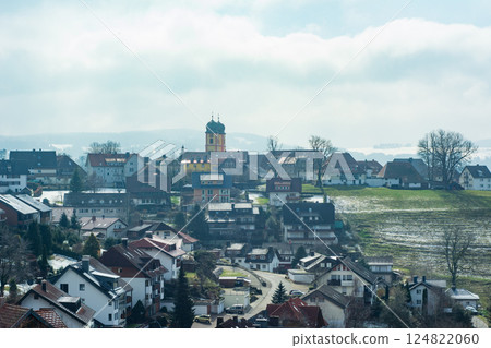 Charming rural town with scattered buildings under a cloudy sky encapsulating tranquil everyday life and natural beauty in early spring 124822060