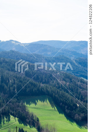 Vast green valleys and majestic hills stretch under a clear sky showcasing nature's beauty in tranquil harmony, inviting exploration and serenity among the landscapes Vast green valleys and majestic hills stretch under a clear sky showcasing nature's beauty in tranquil harmony, inviting exploration and serenity among the landscapes 124822106