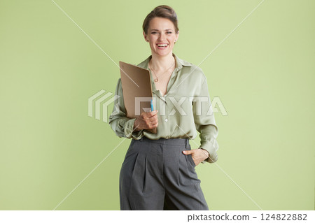 Smiling woman with clipboard in sage green blouse 124822882