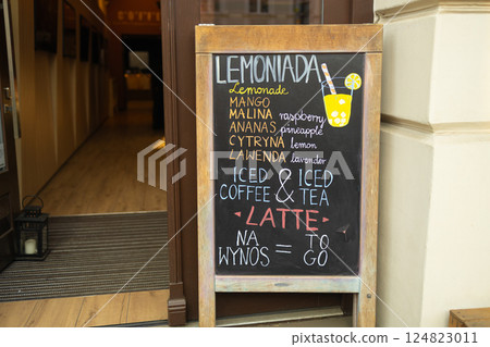 Chalkboard menu with lemonade and iced coffee offers outside a cafe. Chalkboard menu with lemonade and iced coffee offers outside a cafe. 124823011