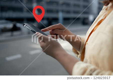 Woman using smartphone with location pin symbol 124823017