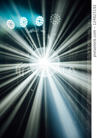 A mirrored disco ball reflects light rays throughout the room. Smoke enhances the visibility A mirrored disco ball reflects light rays throughout the room. Smoke enhances the visibility 124823192