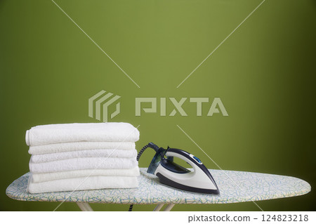 White towels, iron, and olive green wall 124823218