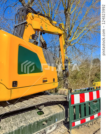 Yellow Excavator at Construction Site, Blue Sky, Heavy Machinery, Urban Development. High quality photo Yellow Excavator at Construction Site, Blue Sky, Heavy Machinery, Urban Development. High quality photo 124823992