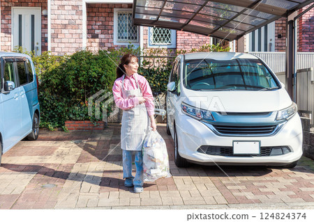 A woman taking out the trash 124824374