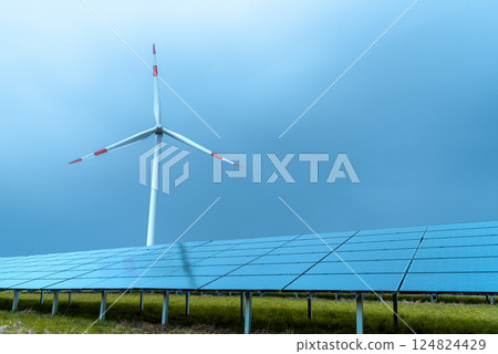 Solar panels close up and the wind turbine in the background Solar panels close up and the wind turbine in the background 124824429