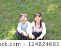 Children (boy and girl) sitting on grass and laughing 124824681