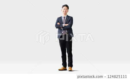 Smiling male businessman standing with his arms folded Smiling male businessman standing with his arms folded 124825111