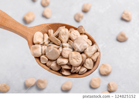 Raw dry Grass pea close up on wooden spoon Raw dry Grass pea close up on wooden spoon 124825152