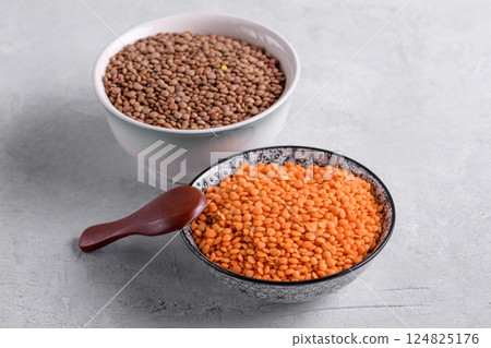 Red and brown lentil in ceramic bowls, close up 124825176