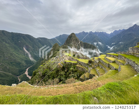 Panoramic view of Machu Picchu | Mysterious Inca city surrounded by clouds and mountains (Peru) 124825317