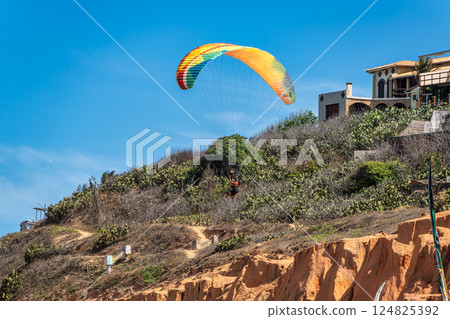 Paraglider pilot at Canoa Quebrada Beach at Aracati in Ceara, Brazil. Bay Coastline Paraglider pilot at Canoa Quebrada Beach at Aracati in Ceara, Brazil. Bay Coastline 124825392