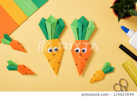 Desktop with cute handmade paper crafts carrots with eyes and smiles and diy art supplies. Top view. Desktop with cute handmade paper crafts carrots with eyes and smiles and diy art supplies. Top view. 124825649