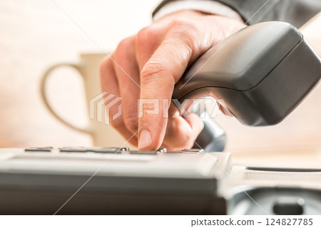 Business adviser dialing out on a land line telephone 124827785