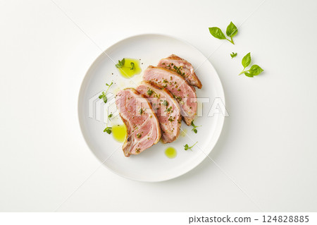 Delicious gourmet dish with fresh herbs on a white plate, perfect for dining and culinary presentation. 124828885