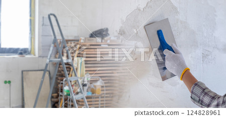 Puttying walls during repairs. 124828961