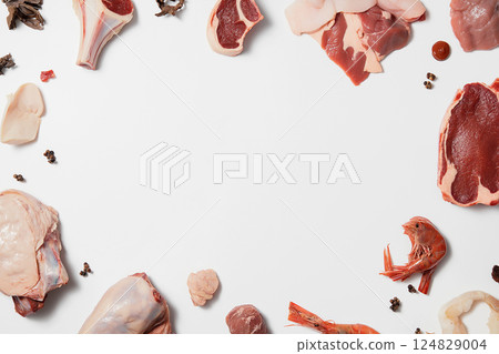 Assorted raw meat and seafood platter with shrimp and beef cuts displayed overhead 124829004