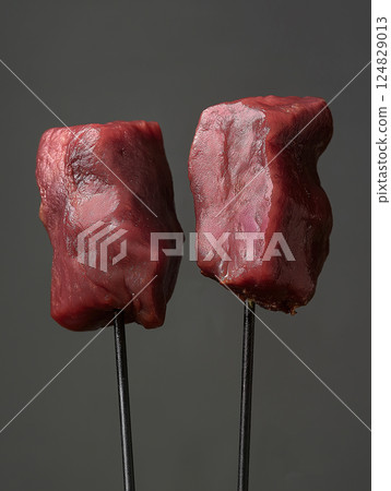 Raw beef meat steak on skewers showcasing juicy red texture and fresh protein-rich ingredient Raw beef meat steak on skewers showcasing juicy red texture and fresh protein-rich ingredient 124829013