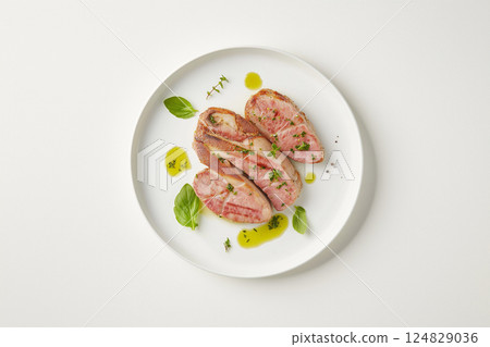 Delicious gourmet meal with herbs, served on a plate with succulent slices of juicy meat Delicious gourmet meal with herbs, served on a plate with succulent slices of juicy meat 124829036